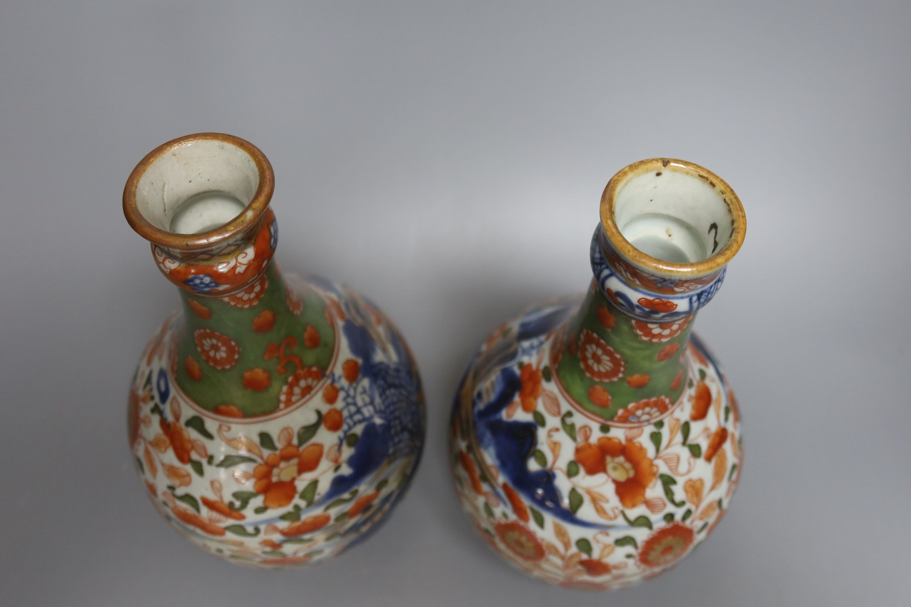 A pair of 18th century Chinese clobbered blue and white bottle vases 23cm